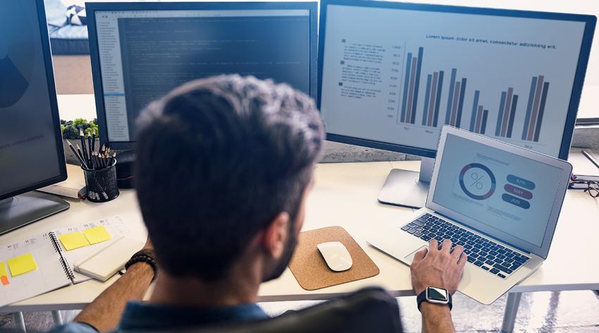 Young person looking at data on screens.